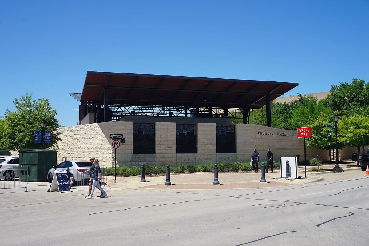 The Levitt Pavilion in downtown Arlington, a steel stage canopy above a limestone wall lettered Founders Plaza