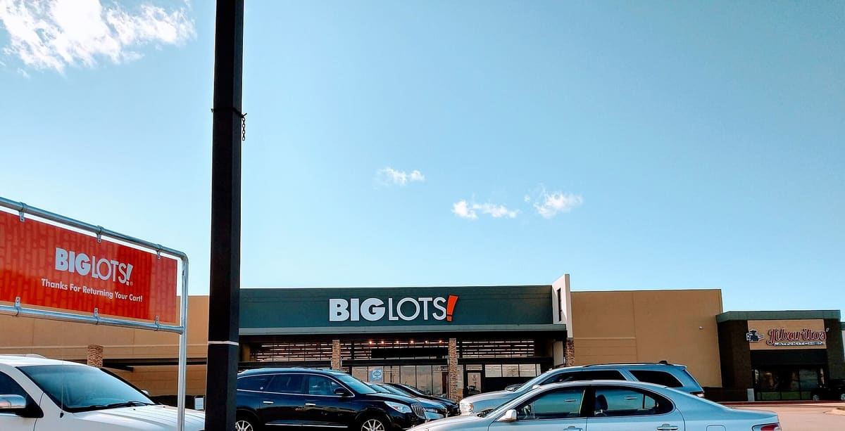 A big-box store and a Latin restaurant in a tan stucco shopping center at Harwood Road and Central Drive in Bedford, Texas, with cars parked out front
