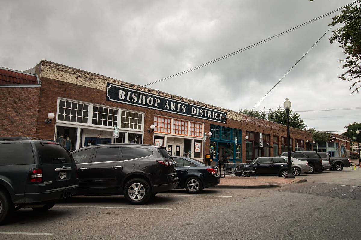 One-story brick storefronts with painted Bishop Arts District sign in north Oak Cliff, Dallas