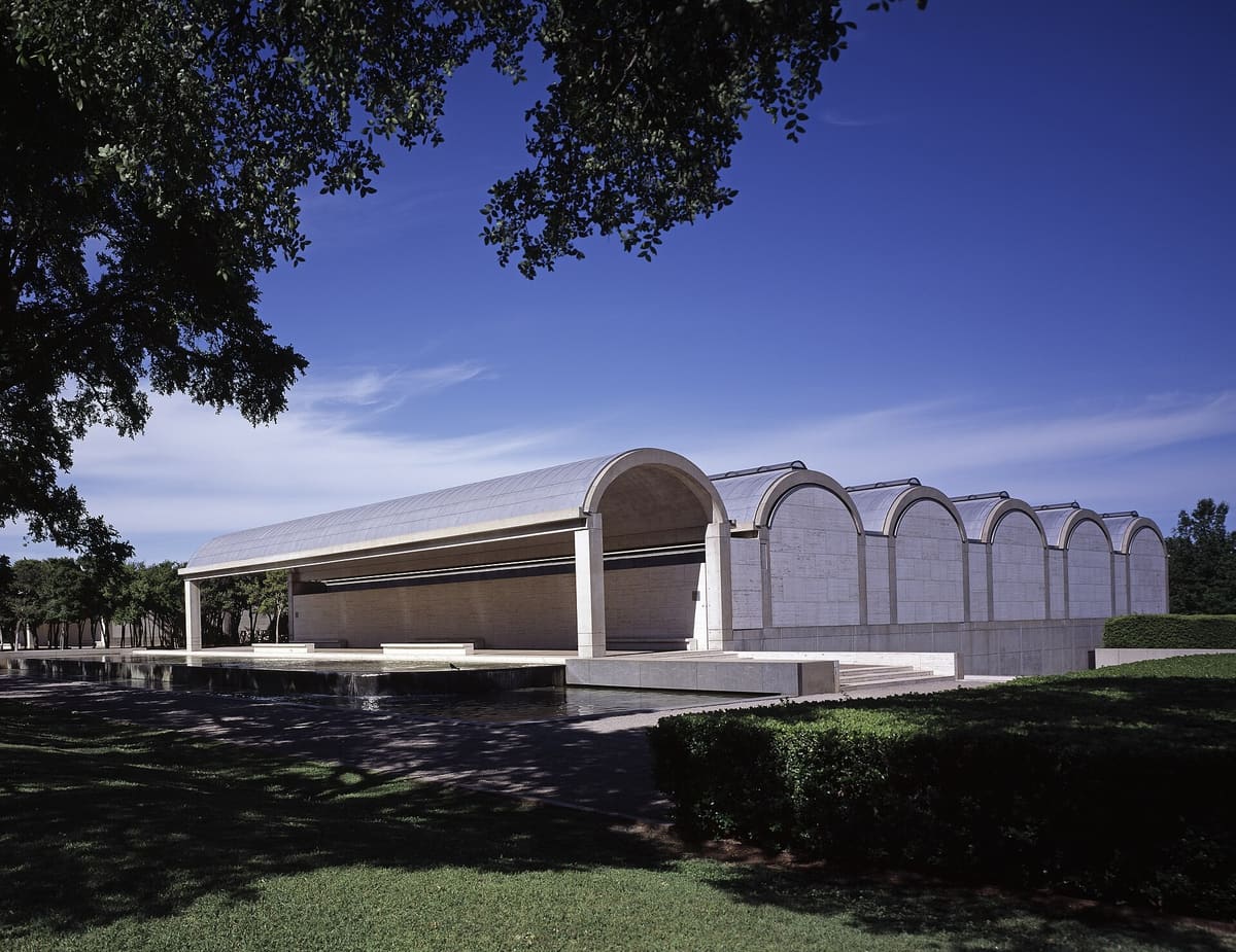 The Kimbell Art Museum's row of cycloid barrel vaults and open portico beside a reflecting pool under live oaks