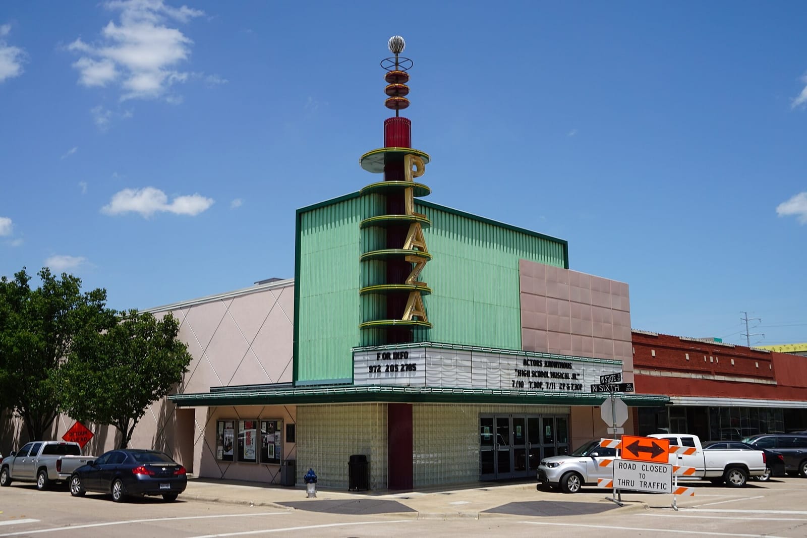 The Plaza Theatre on West State Street in downtown Garland, Texas, with its green Moderne facade, glass block entry, and tall vertical PLAZA sign