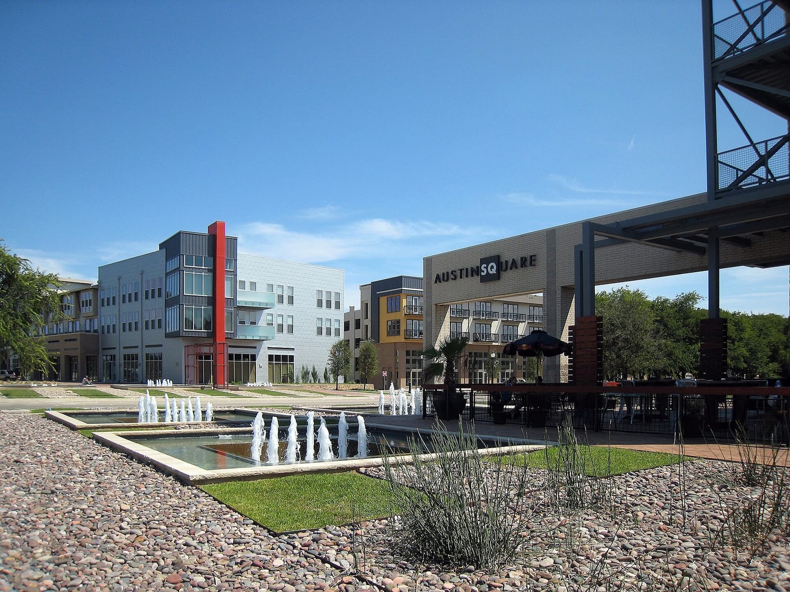 Austin Square at Austin Ranch in The Colony, with stepped fountain pools in front of four-story mixed-use buildings and a covered restaurant patio