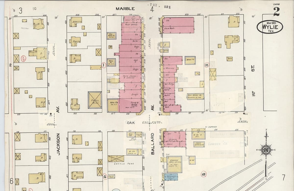 A 1934 Sanborn fire insurance map of downtown Wylie, Texas, showing storefront blocks shaded pink along both sides of Ballard Avenue between Marble and Oak streets