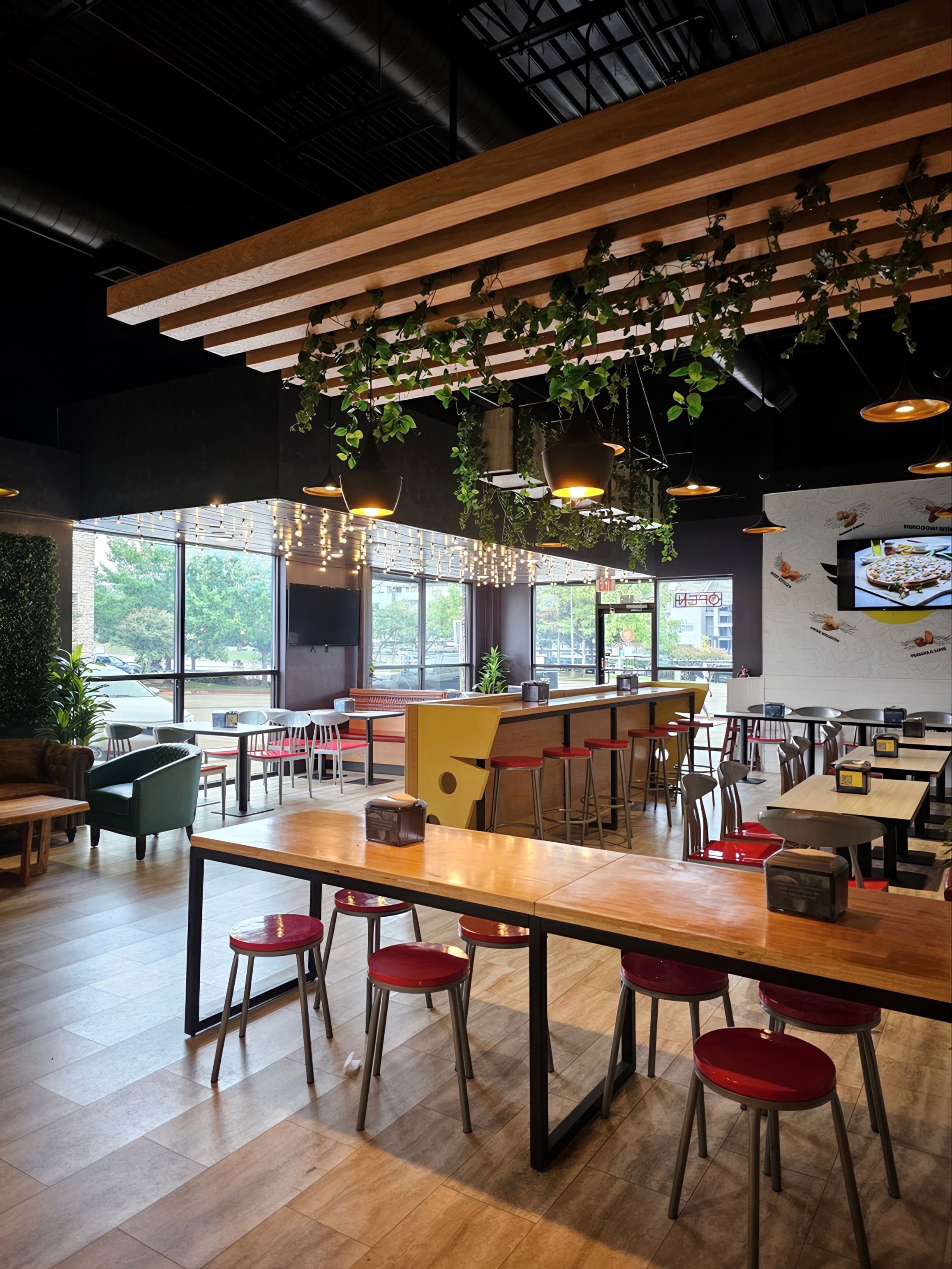 Dining tables under the new pendant lighting and suspended planters.