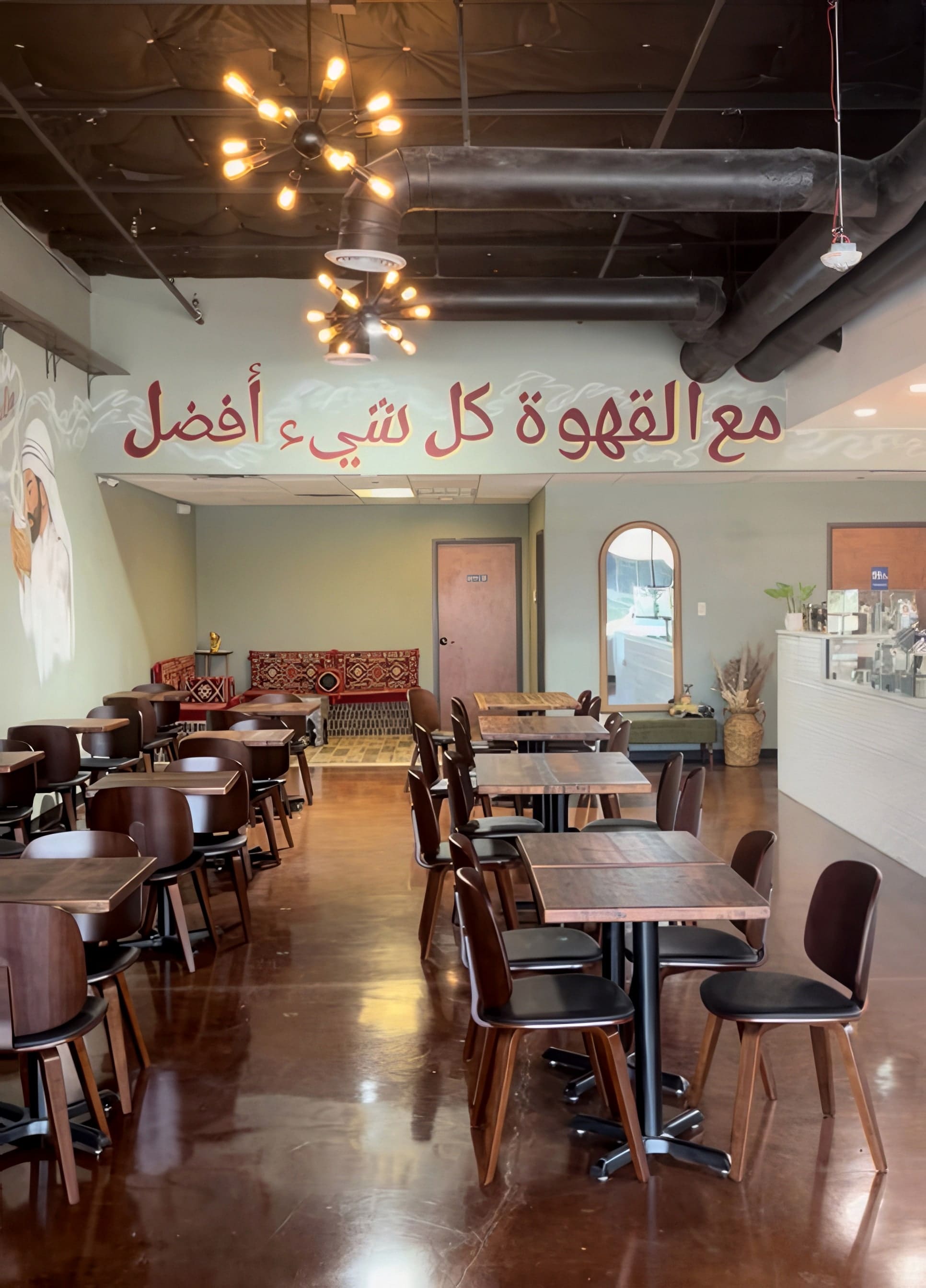 Sayfani Coffee House seating area in Allen, Texas with the hand-painted calligraphy mural, sputnik pendants, and walnut tables